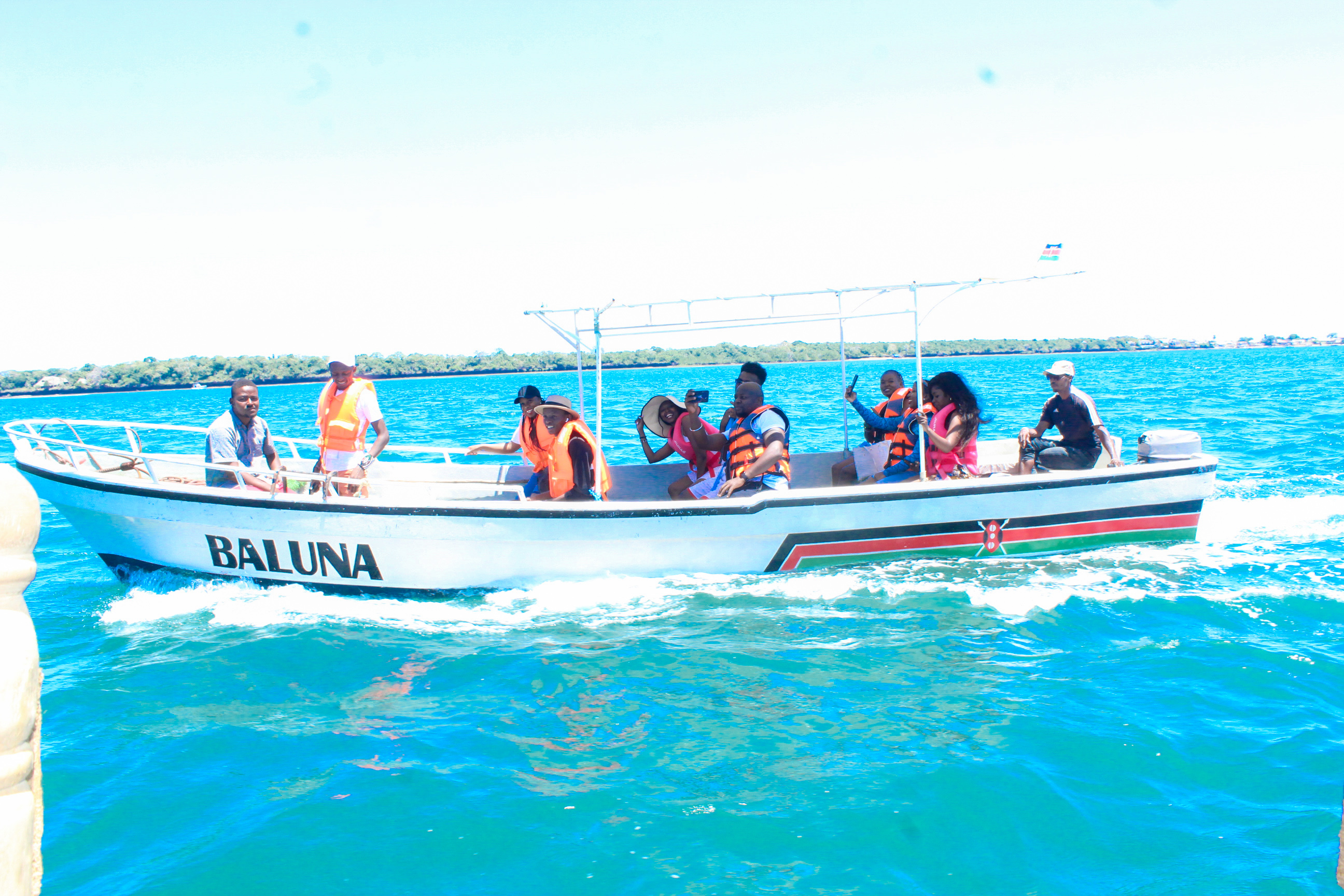 Tourists enjoying a traditional dhow boat safari on the crystal-clear Kenyan coast